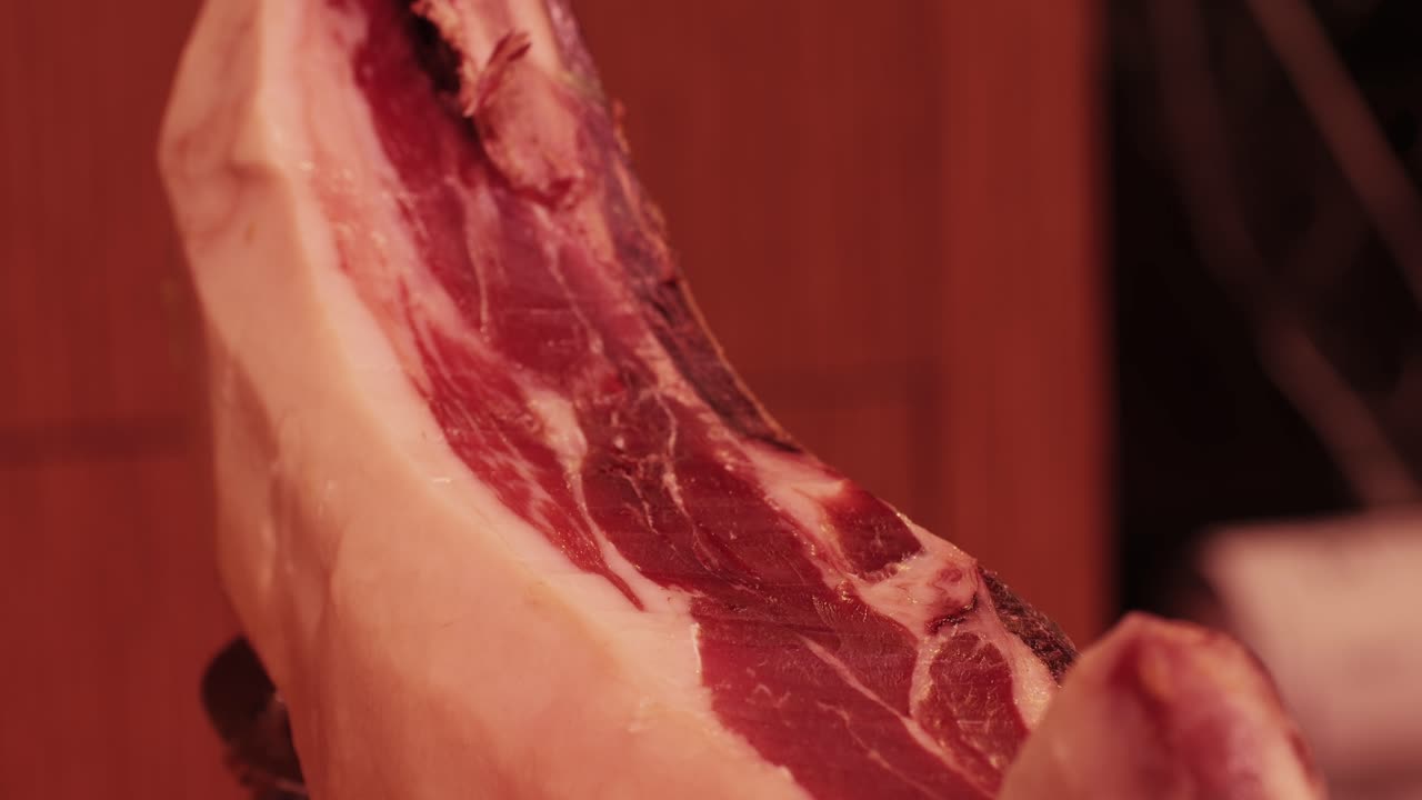 Close-up shot of hanging cured hams in a traditional setting, showcasing the rich textures and colors.