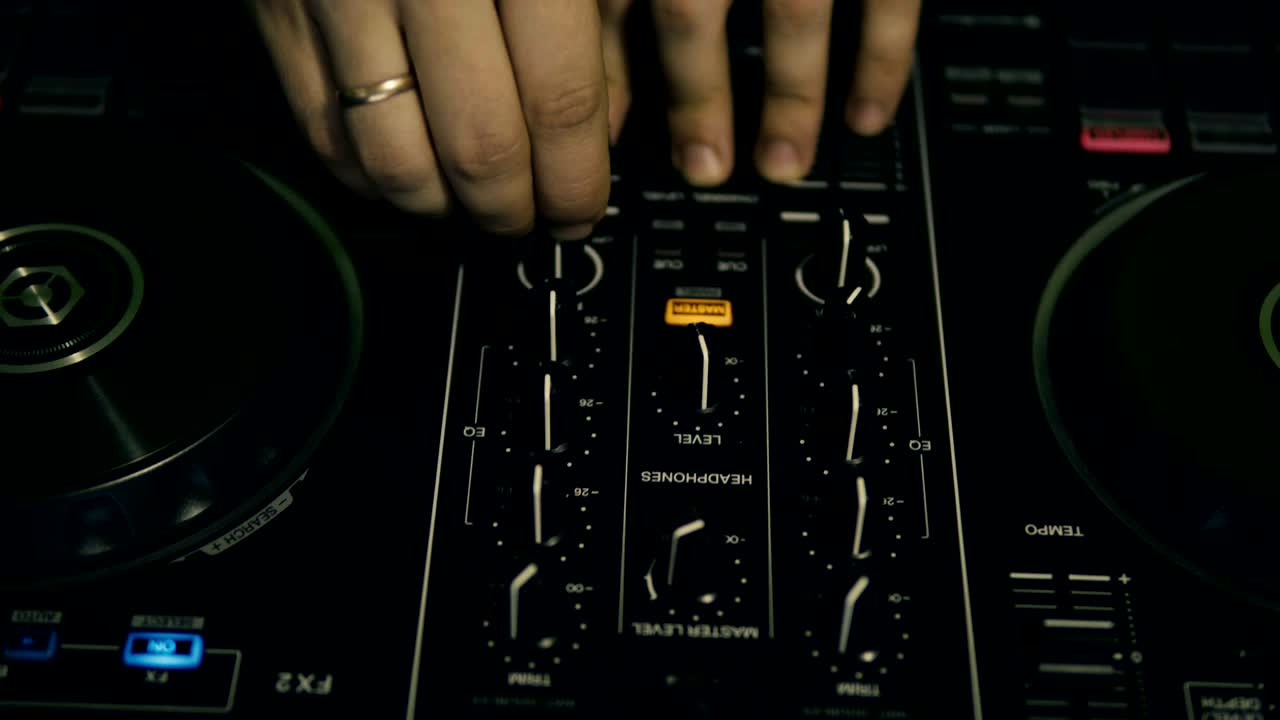 DJ tweak track controls on DJ control panel.