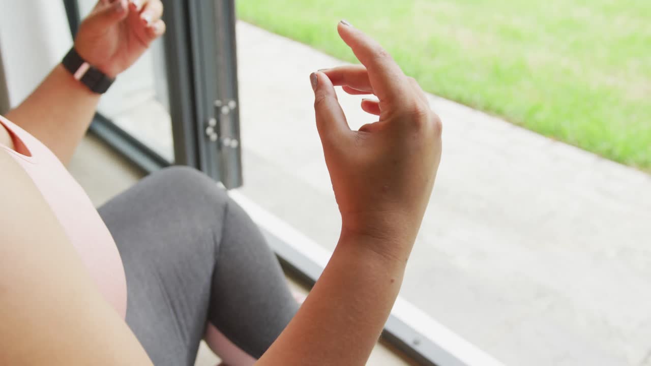 video de manos de tamaño grande mujer afroamericana haciendo ejercicio en casa, practicando yoga