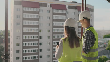 building workers working at construction site builders looking in blueprint back view copy space. building development teamwork and people concept.