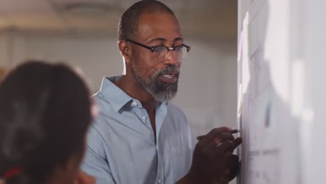 professional businessman discussing while writing on the whiteboard in modern office in slow motion