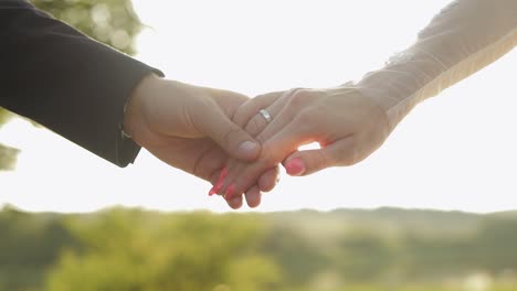 Hands-of-bride-and-groom-in-sunbeams.-Wedding-couple.-Happy-family.-Newlyweds