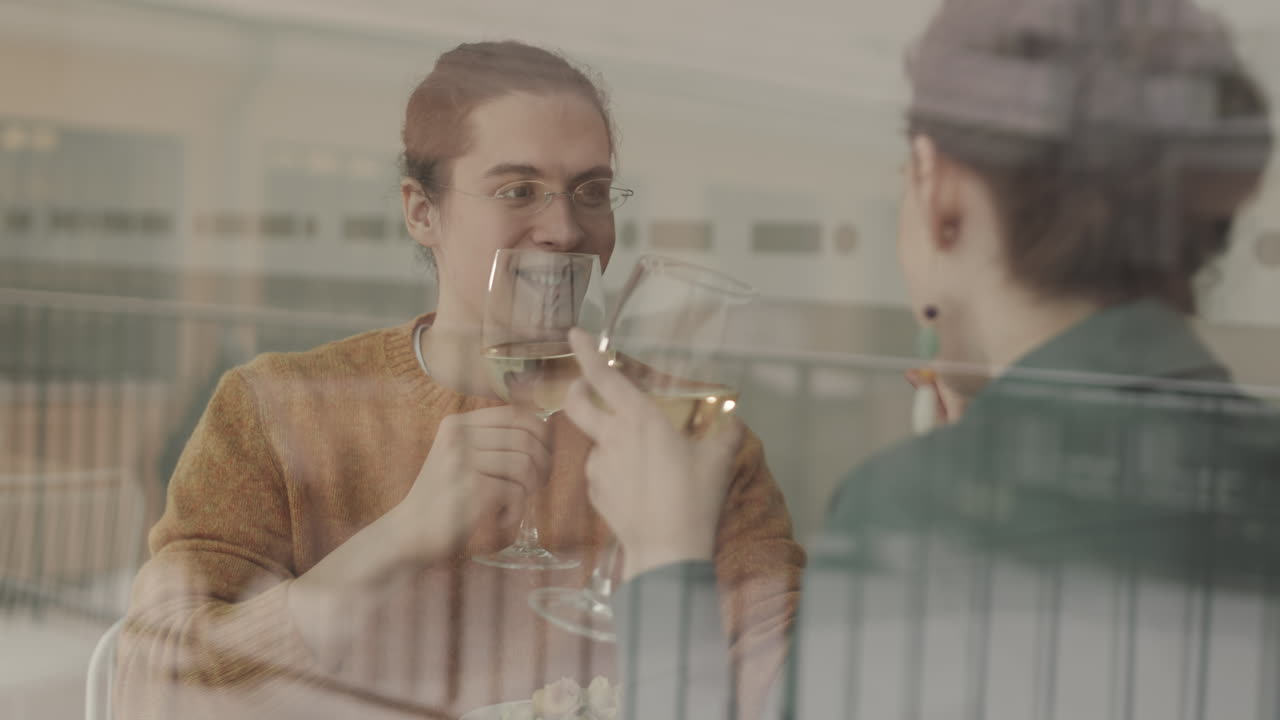 hombre y mujer bebiendo vino durante la cena en una cafetería