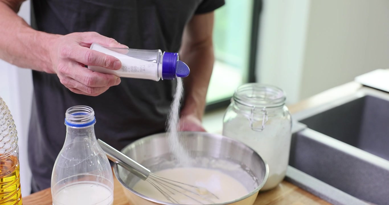 Chef esperto aggiunge sale nell'impasto liscio dei pancake