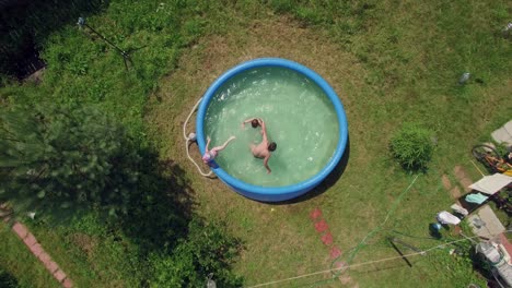 children in the pool and village aerial shot