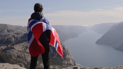 woman with a waving flag of norway on the background of nature