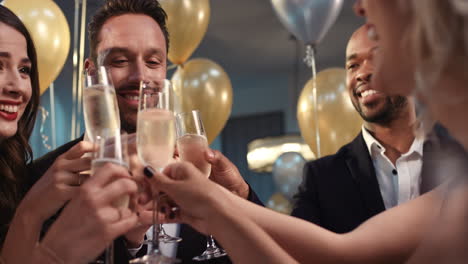 friends holding up champagne flutes together in a toast at party