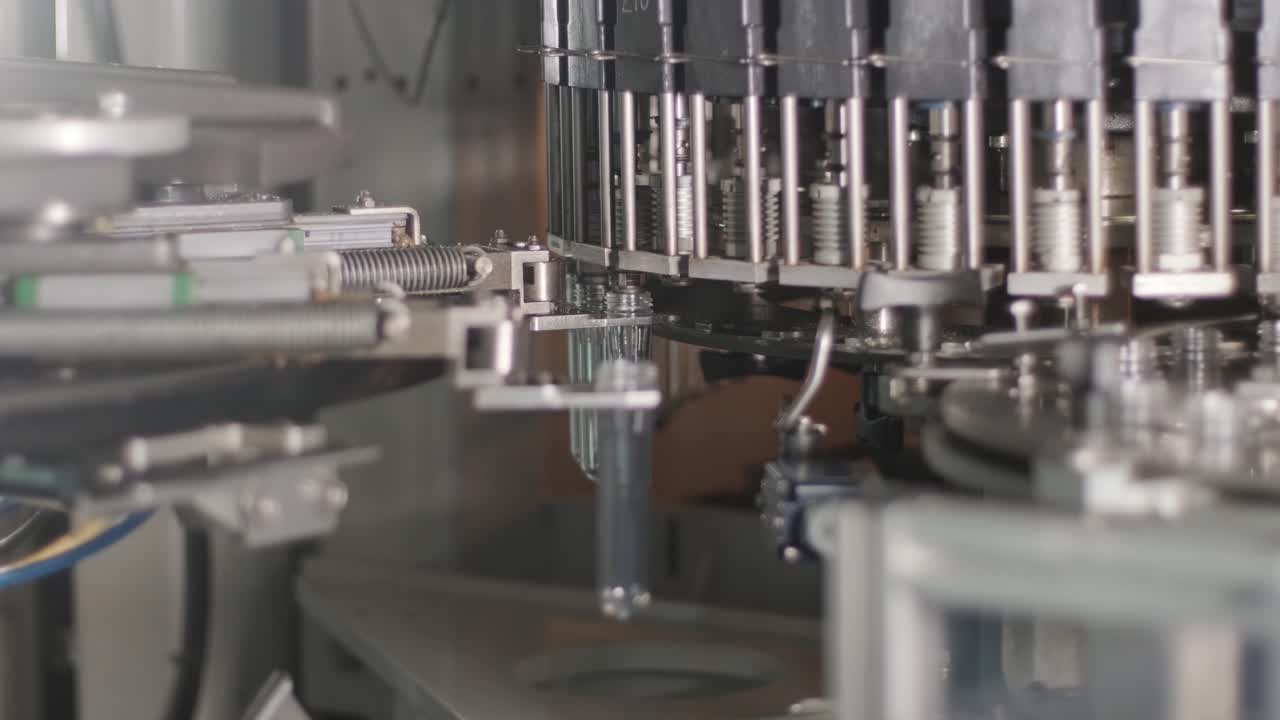 Automatic filling machine pours water into plastic PET bottles at modern beverage plant