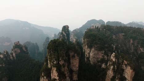 aerial view of temple perched above forested sandstone peaks and deep valleys in the mystical terrain of zhangjiajie national park