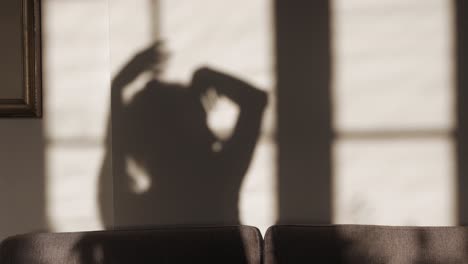 sombra de mujer bailando y escuchando música en casa