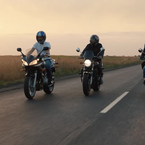 a group of bikers rides on the highway in the evening at sunset 1