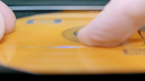 close-up shoot of a person inserting a cd in a portable drive.