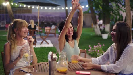 Felices,-Tres-Mujeres-Atractivas-Divirtiéndose-Y-Bailando-En-El-Restaurante-Al-Aire-Libre-Al-Atardecer