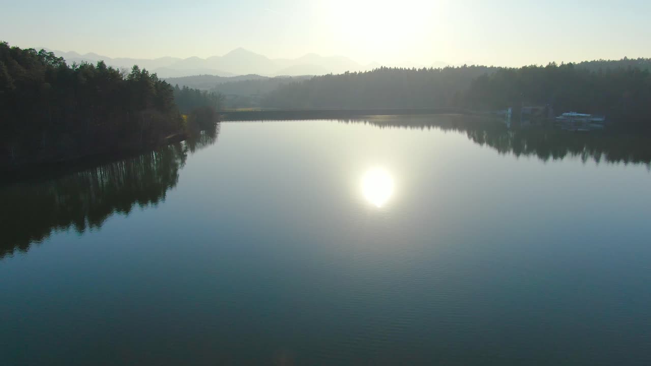Cinematic fly over calm water of Smartinsko lake. Artificial lake, Slovenia