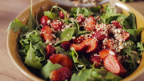 strawberry arugula salad with sesame seeds and pine nuts