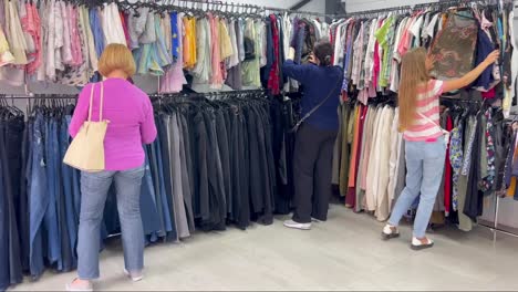 Women Shopping for Sportswear in a Magenta Boutique in the City a Group of Women are Browsing through a Clothing Store Exploring Various Options from Tshirts to Sportswear in a City Boutique