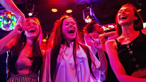 group of happy women dancing at a nightclub