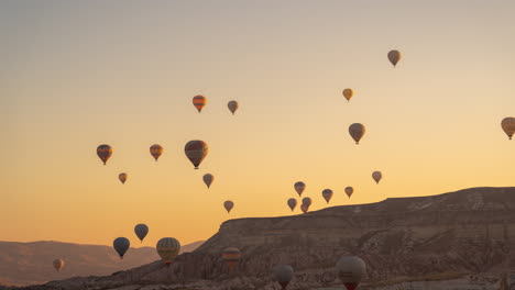 Time-Lapse-of-Hot-Air-Balloons-in-Cappadocia,-Turkey-at-Morning-Flying-Above-Hills