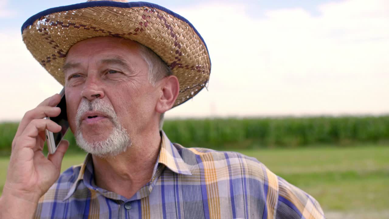 un granjero moderno hablando por teléfono móvil.