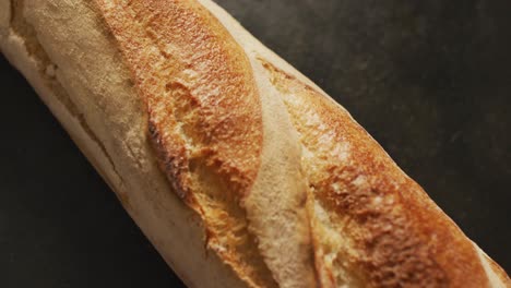 Video-of-close-up-of-baguette-on-a-black-surface