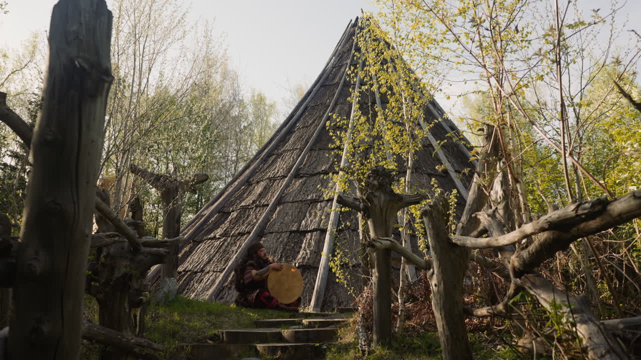 hombre obeso en ropa étnica sostiene tambor chamánico cerca de ail