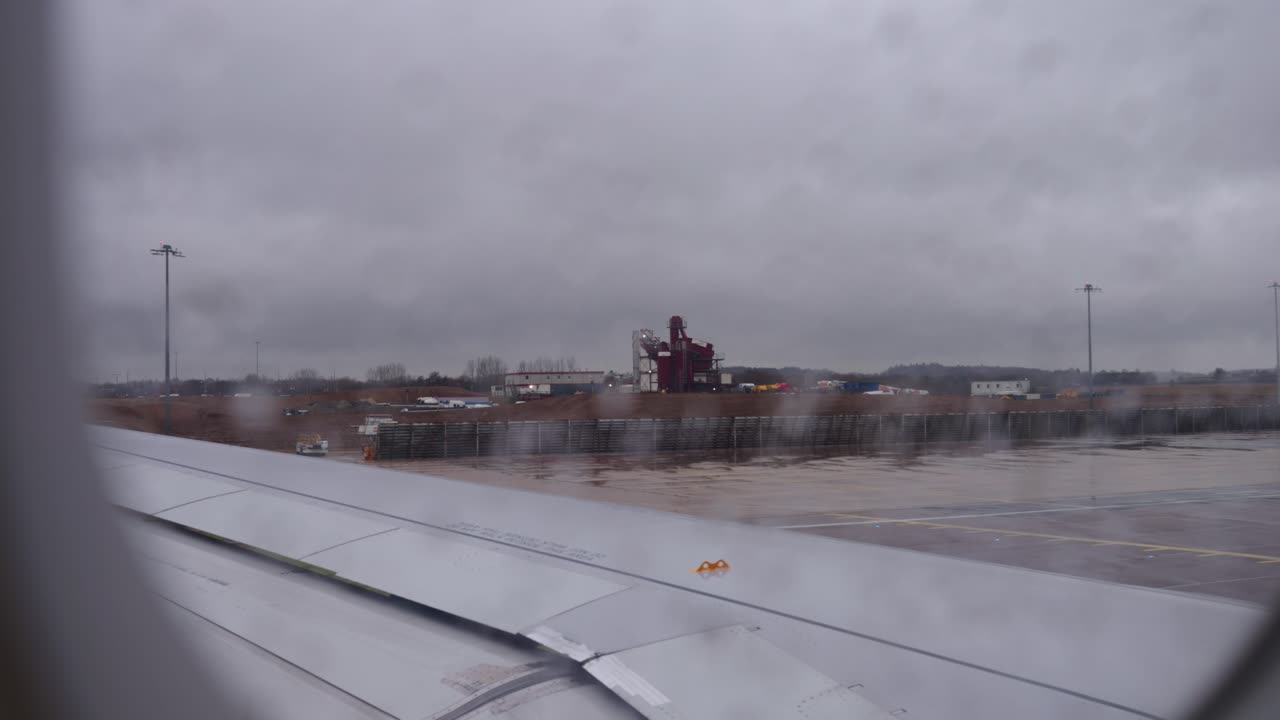 Aereo in rullaggio (POV dalla finestra) all'aeroporto in una giornata piovosa