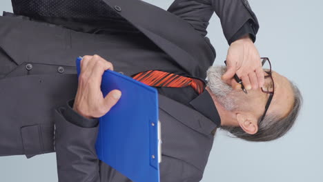 vídeo vertical de un viejo hombre de negocios bostezando.