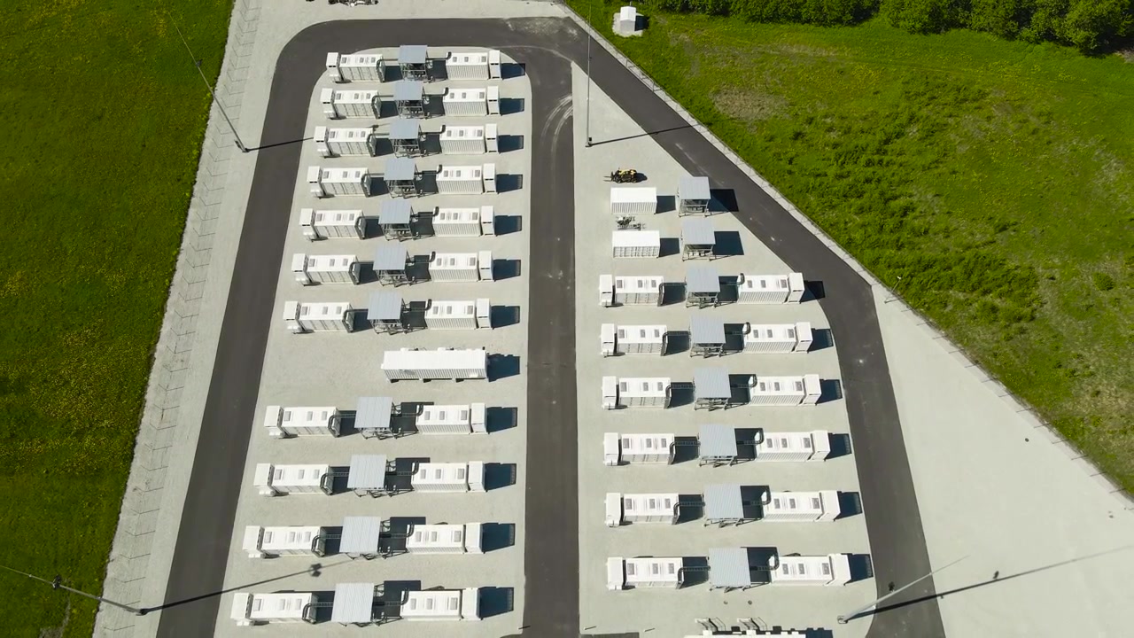 Impianto moderno di accumulo di energia a batteria con container bianchi che immagazzinano energia pulita da fonti rinnovabili, mostrando tecnologia sostenibile per il futuro dell'elettricità verde e la stabilità della rete