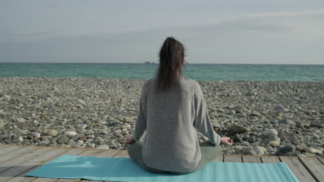 mujer meditando en una playa