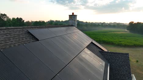 Dew-covered-solar-panels-during-morning-in-rural-USA-on-residential-house-with-shingle-roof