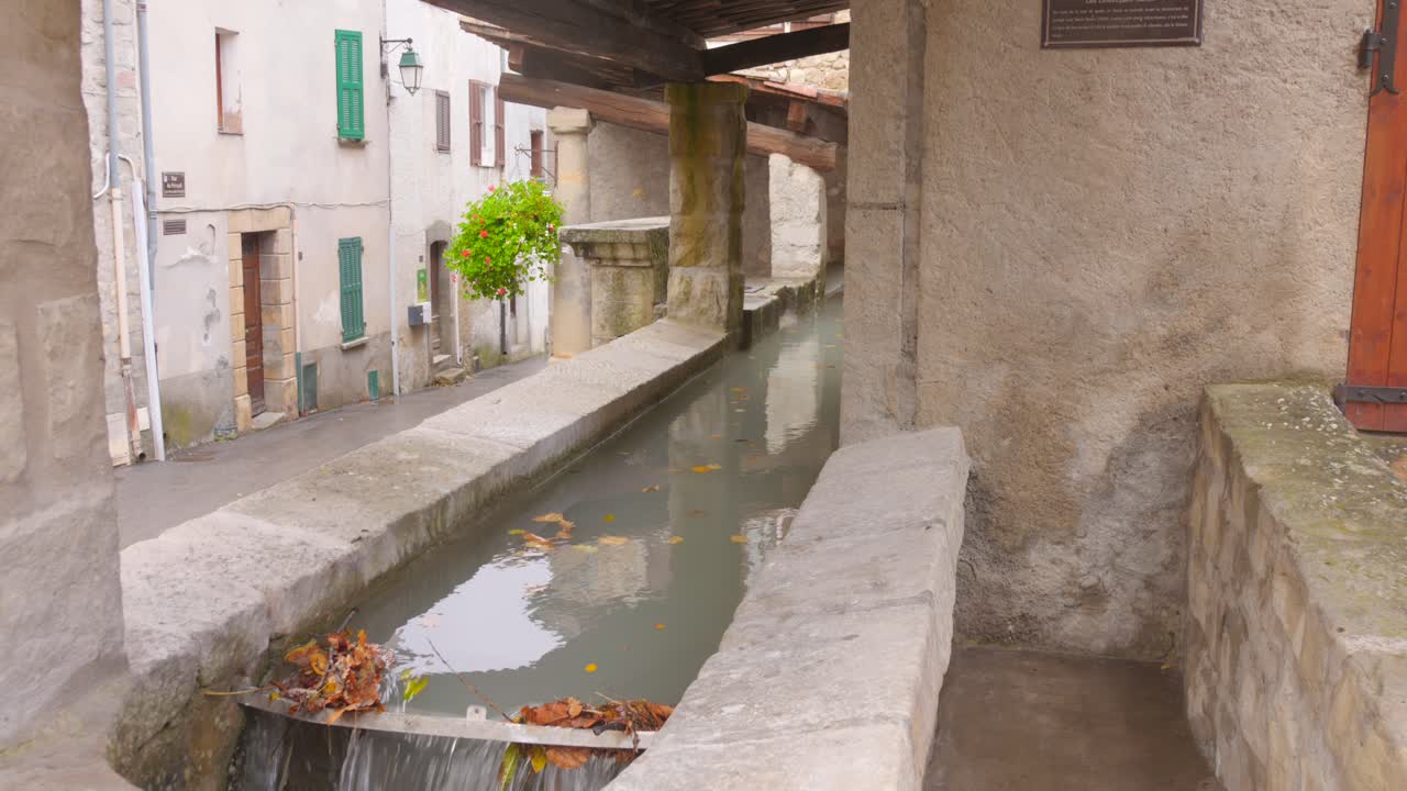 Agua fluyendo por un canal de hormigón en el casco antiguo de Annot, Sur de Francia
