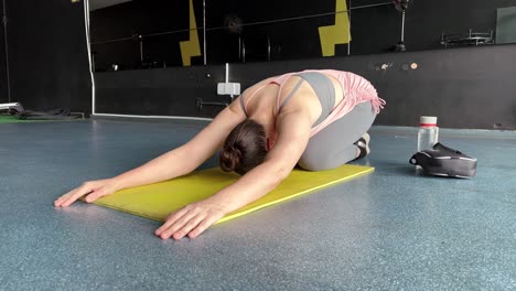 young fit women doing yoga doing asanas in bright yoga studios, yoga a form of physical relaxation, woman lying on a mat