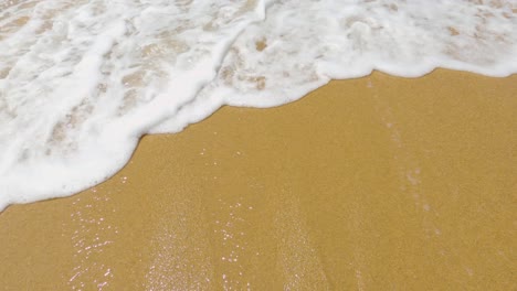 sea wave covering beach sand