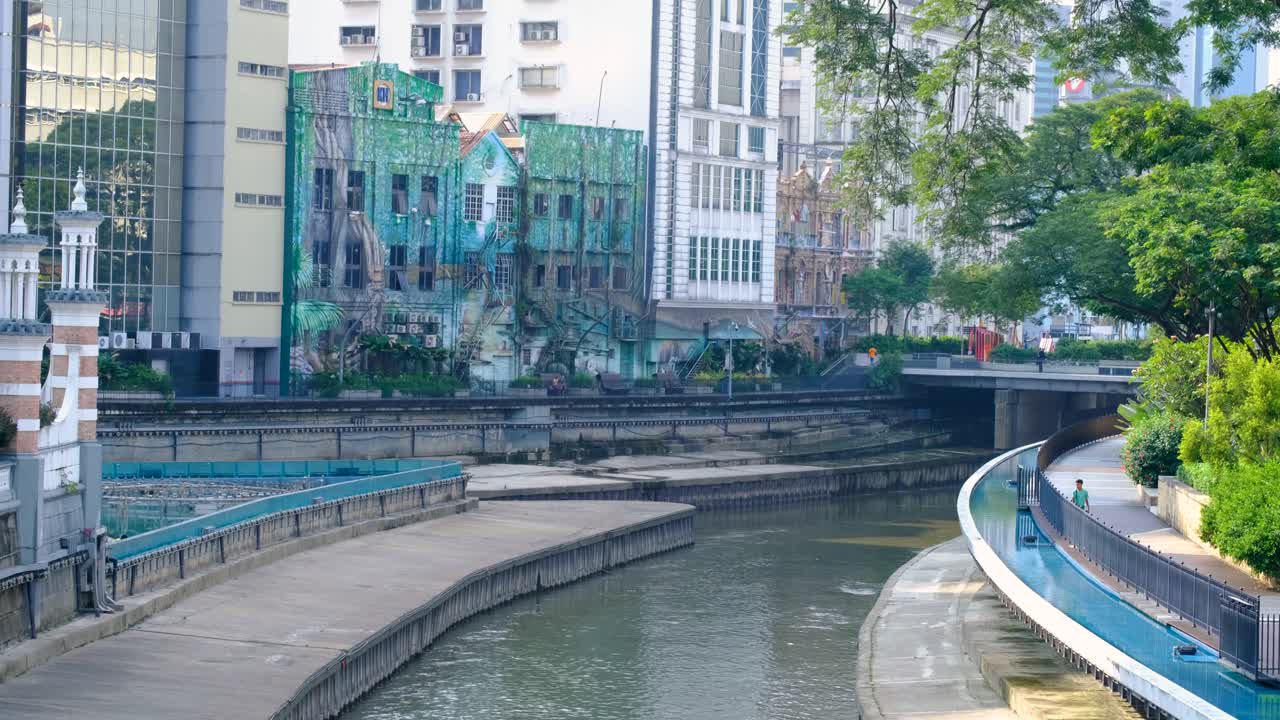Scenic view of River of Life cultural walk along the Klang River lined by urban buildings in capital city of Kuala Lumpur Malaysia