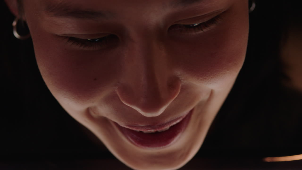 테이블 컴퓨터를 사용하는 아름다운 아시아 여성 영화를 보고 웃고 코미디 엔터테인먼트를 즐기고 집에서 휴식을 취하고 있습니다.