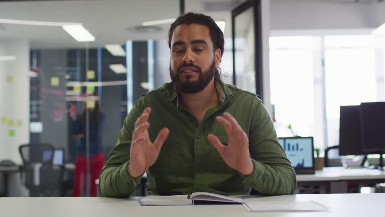 feliz hombre de negocios de raza mixta sentado en el escritorio haciendo una videollamada