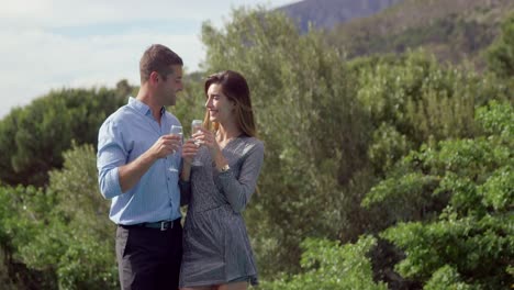 couple drinking champagne next to swimming pool