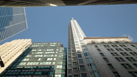 Edificios-Altos-Y-Modernos-En-El-Centro-De-La-Ciudad-Urbana-Con-Torres-Altas-Que-Miran-Hacia-El-Cielo-Azul-Claro