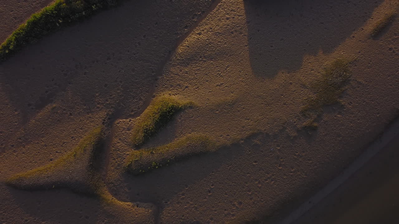 disparo aéreo de arriba hacia abajo que se eleva para revelar marismas al atardecer en el norte de norfolk, reino unido