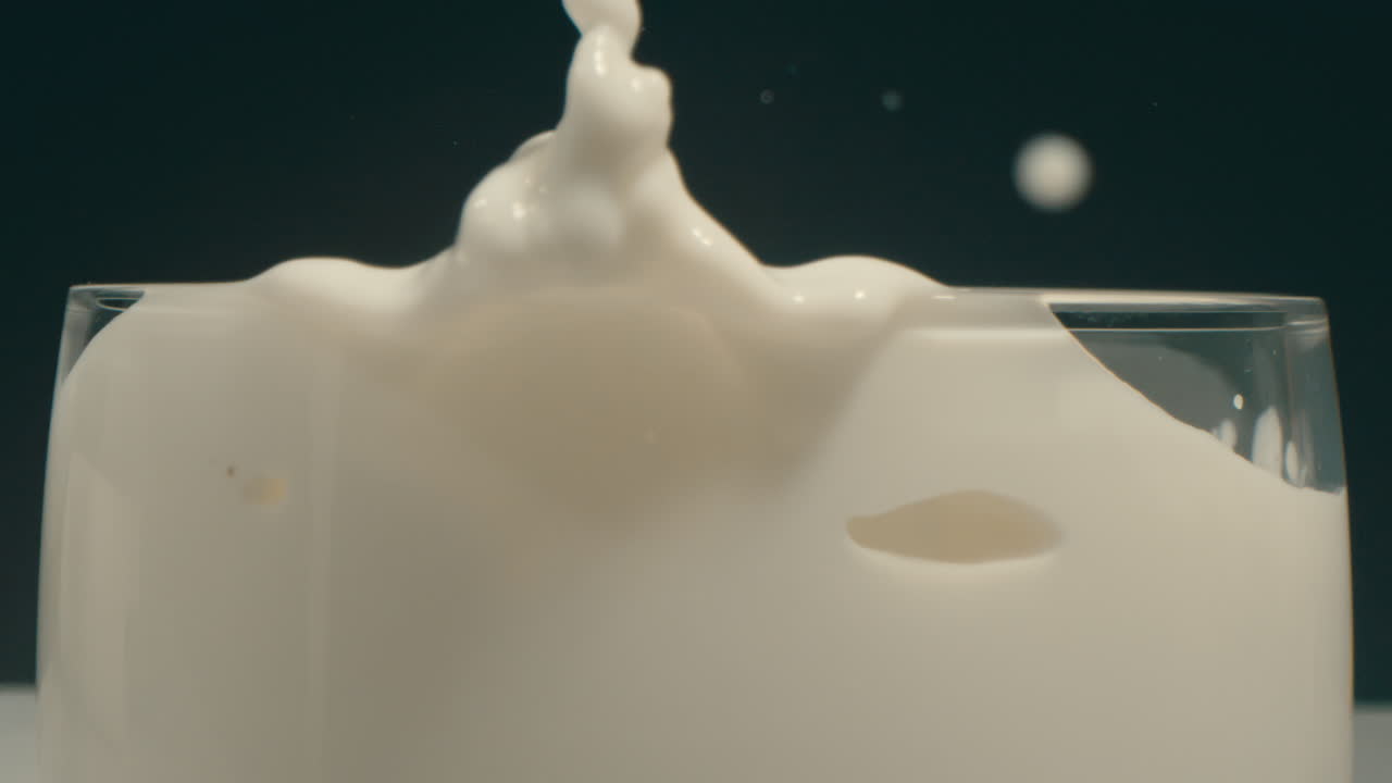 десерт с печенье орео падает в стакан белого молока и брызгает вверх по стороне в замедленном движении