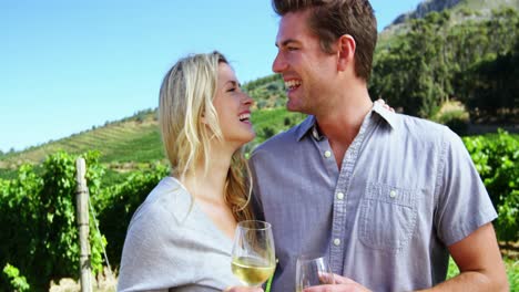 Woman-kissing-man-while-toasting-wine-in-vineyard