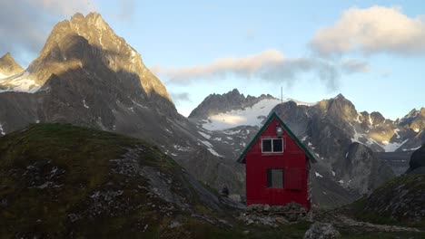 Timelapse-of-clouds-passing-behind-the-Mint-Hut-in-Alaska's-backcountry-terrain