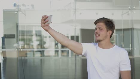 Handsome-bearded-man-recording-video-with-help-of-smartphone.