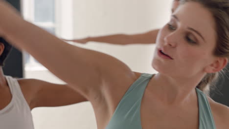 Yoga-Kurs-Einer-Schönen-Kaukasischen-Frau,-Die-Kriegerpose-Praktiziert-Und-Einen-Gesunden-Lebensstil-Genießt,-Der-Ihren-Körper-Dehnt-Und-In-Der-Gruppenmeditation-Im-Fitnessstudio-Trainiert