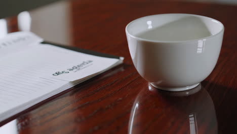 office agenda and cup on wooden table