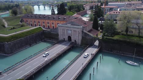 beautiful bridges in peschiera del garda with passing cars