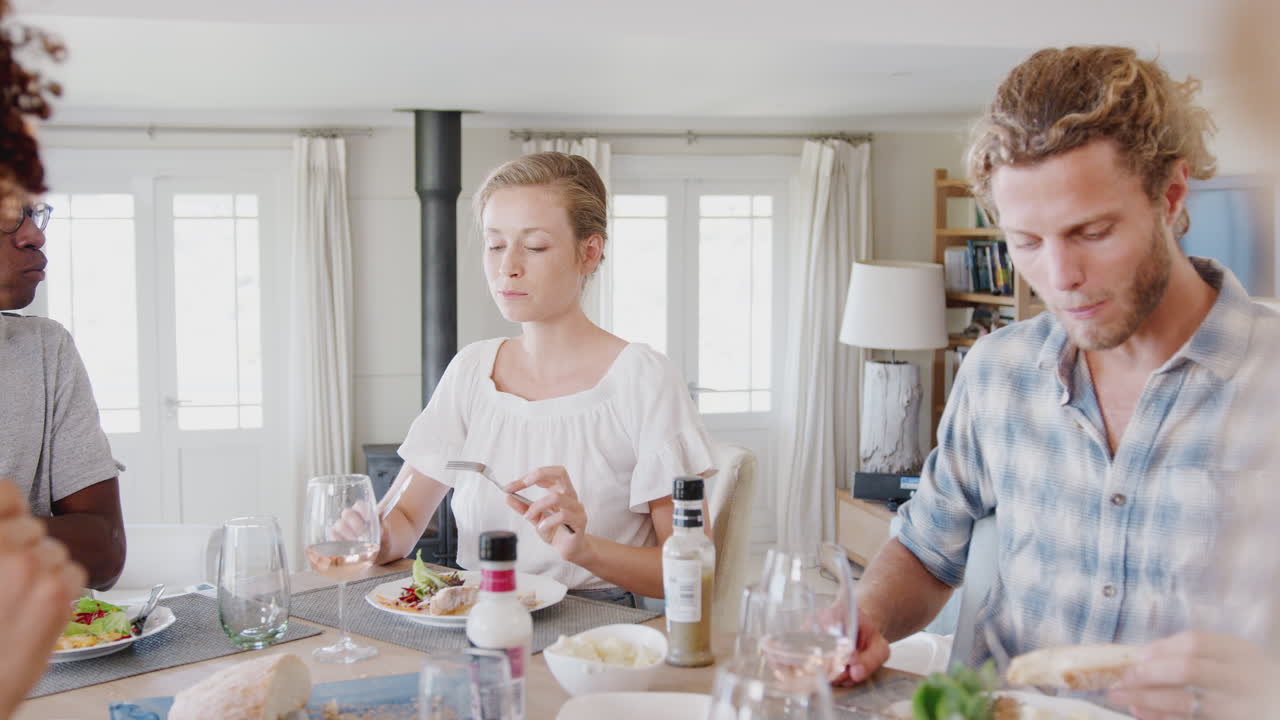 집 에서 테이블 주위에 앉아 함께 식사를 즐기는 젊은 친구 들 의 그룹