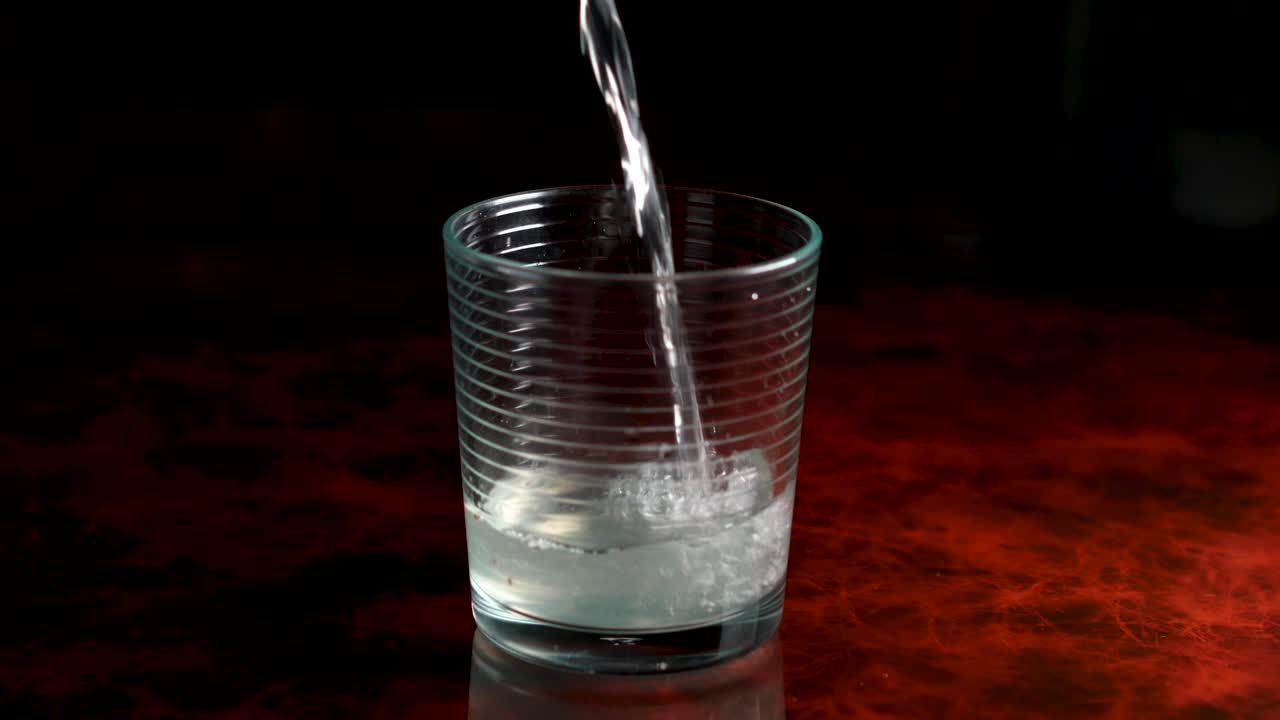 derramando limonada com sementes de chia em um copo de cristal com um belo fundo elegante e algum espaço em preto