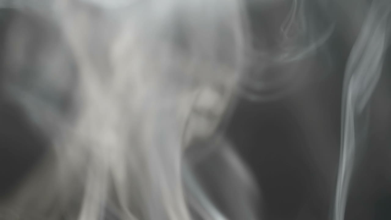 Slow motion. Puffs on a black background. Smoke from fire