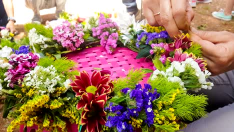 woman constructing a wreath of flowers at 1 of may holiday in greece.